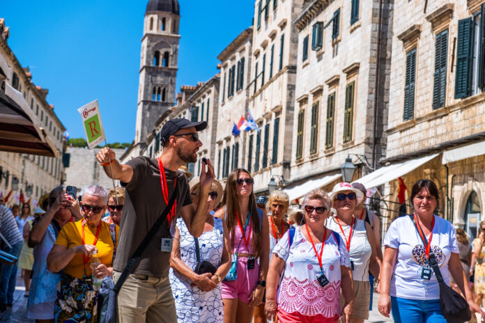 Tour Guide Leading Group on Stradun, Dubrovnik, Croatia Tour Guide Leading Group on Stradun, Dubrovnik, Croatia